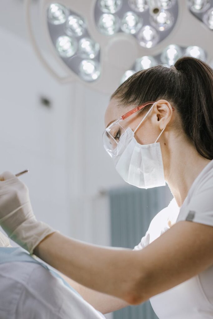 pexels-photo-8413334-8413334 Female dentist working on a patient in a modern dental office with bright lighting.